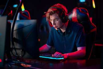 Game of a young guy wearing headphones in a video game in a computer club