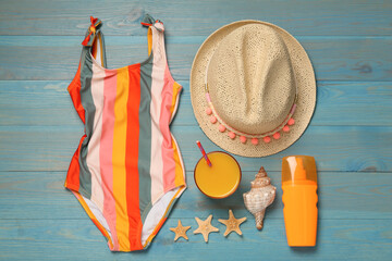 Flat lay composition with beach accessories on light blue wooden background