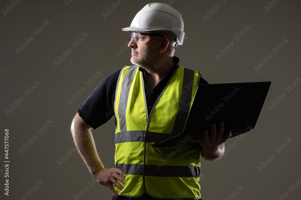 Poster builder with a laptop in his hands. construction engineer with laptop. computer in hands of builder.