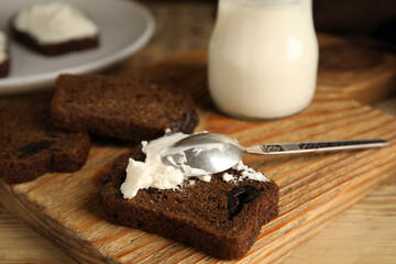 Delicious cream cheese and bread on wooden table
