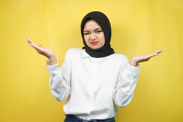 Beautiful asian young muslim woman with i don't know sign expression, isolated on yellow background