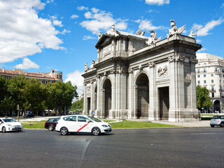 Fototapeta premium Public Monument La Puerta De Alcala arch, Madrid, Spain Bounded by a Traffic Circle