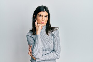 Young hispanic woman wearing casual clothes thinking concentrated about doubt with finger on chin...