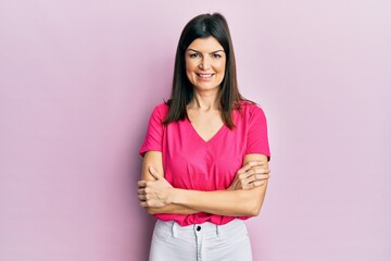 Fototapeta premium Young hispanic woman wearing casual clothes happy face smiling with crossed arms looking at the camera. positive person.