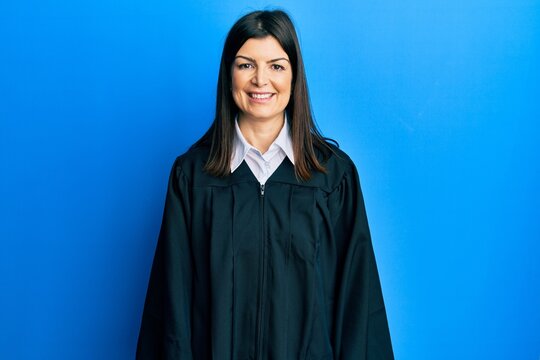 Young hispanic woman wearing judge uniform with a happy and cool smile on face. lucky person.