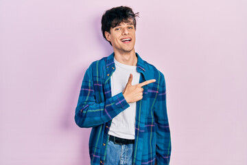 Handsome hipster young man wearing casual white t shirt and vintage shirt cheerful with a smile of face pointing with hand and finger up to the side with happy and natural expression on face