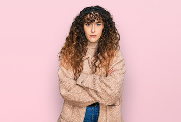 Young hispanic girl wearing winter clothes skeptic and nervous, disapproving expression on face with crossed arms. negative person.