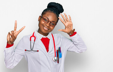 Young african american woman wearing doctor uniform and stethoscope showing and pointing up with...