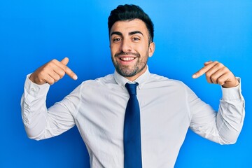 Young hispanic man wearing business clothes looking confident with smile on face, pointing oneself with fingers proud and happy.