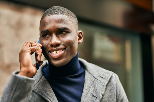 Young african american man smiling happy talking on the smartphone at the city
