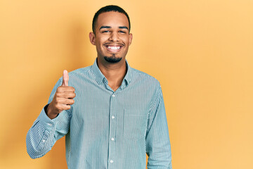 Young african american man wearing casual clothes smiling happy and positive, thumb up doing excellent and approval sign