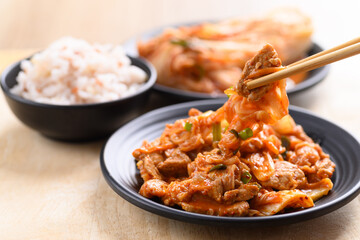 Korean food, Stir-fried kimchi cabbage with pork eating with cooked rice by chopsticks