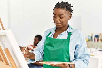 African american painter couple smiling happy painting at art studio.