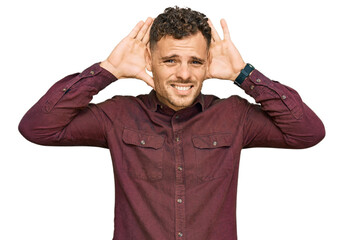 Young hispanic man wearing casual clothes trying to hear both hands on ear gesture, curious for gossip. hearing problem, deaf