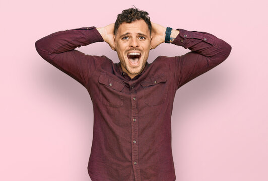 Young hispanic man wearing casual clothes crazy and scared with hands on head, afraid and surprised of shock with open mouth