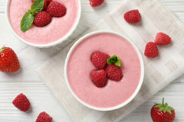 Delicious raspberry mousse with mint on white wooden table, flat lay