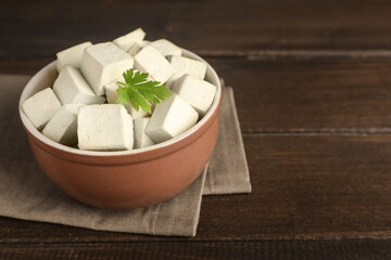 Delicious tofu with parsley on wooden table. Space for text