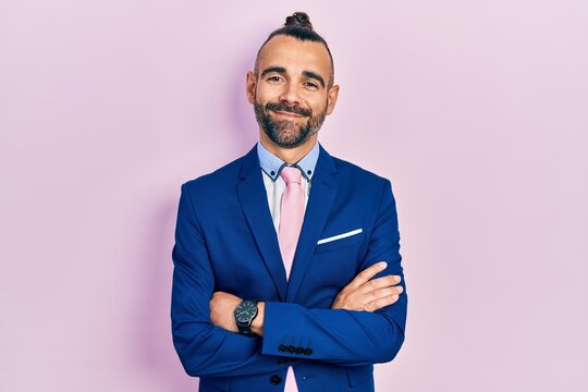 Young hispanic man wearing business suit with arms crossed gesture smiling with a happy and cool smile on face. showing teeth.