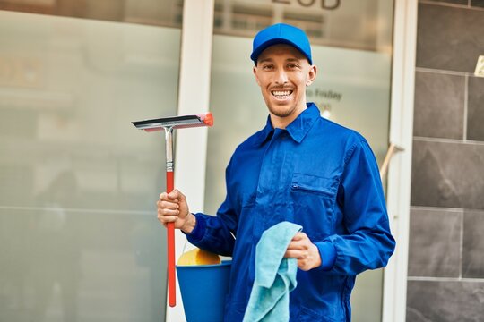Young caucasian glass washer man smiling happy standing at the city.