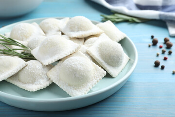 Homemade uncooked ravioli on blue wooden table, closeup
