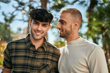 Young gay couple smiling happy and hugging at the city.