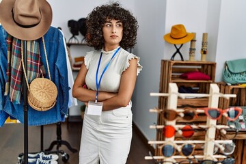 Young middle east shopkeeper woman with serious expression standing with arms crossed gesture at...