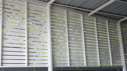 Horizontal white slats. Shaded battens on the side of the house with copy space. Selective focus