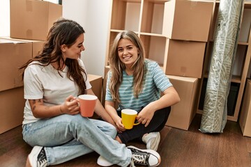 Young couple smiling happy drinking cup of coffee at new home.