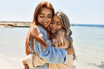 Fototapeta na wymiar Young lesbian couple of two women in love at the beach. Beautiful women together at the beach in a romantic relationship