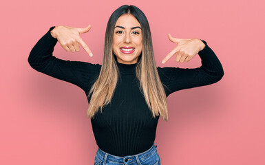 Young hispanic woman wearing casual clothes looking confident with smile on face, pointing oneself...