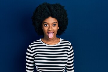 Fototapeta na wymiar Young african american woman wearing casual clothes sticking tongue out happy with funny expression. emotion concept.