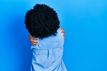Young african american woman wearing casual clothes hugging oneself happy and positive from...