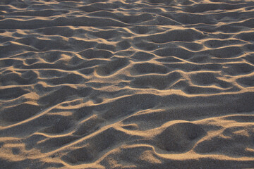 Sand am Sandstrand am Meer, von zahllosen nackten Füßen zertreten, die dort Urlaub machen
