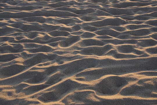 Sand am Sandstrand am Meer, von zahllosen nackten Füßen zertreten, die dort Urlaub machen