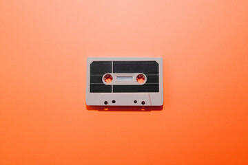 Fototapeta premium Audio cassette tape isolated on orange background. Copy space
