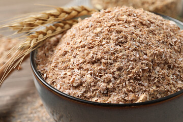 Wheat bran and spikelets in bowl, closeup