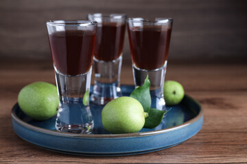 Delicious liqueur and green walnuts on wooden table