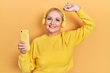 Young blonde woman dancing wearing headphones smiling with a happy and cool smile on face. showing teeth.