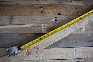 Carpenters measuring tape on wooden background