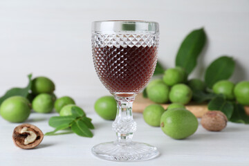 Delicious liqueur and fresh walnuts on white wooden table