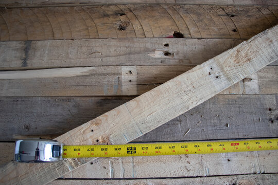 Carpenters measuring tape on wooden background