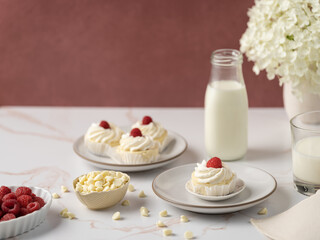Light and airy arrangement of cheesecake , milk, raspberries and flowers on a table