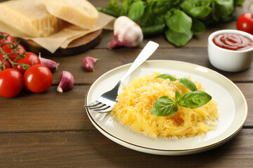 Tasty spaghetti squash with basil and cheese served on wooden table