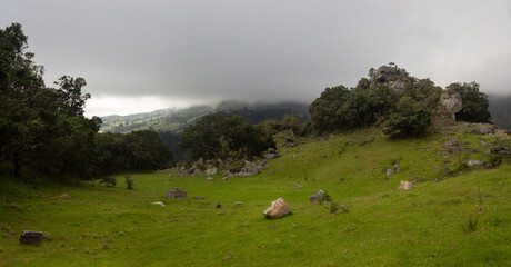 Fototapeta premium Colombian andean mountain countryside landscape with a monolith hills, big stones and a green valey in cloudy day