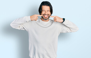 Naklejka premium Middle age caucasian man wearing casual clothes smiling cheerful showing and pointing with fingers teeth and mouth. dental health concept.