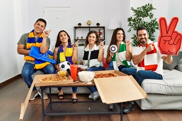 Group of young people wearing team scarf cheering football game smiling happy pointing with hand and finger to the side