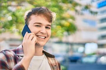 Young caucasian man smiling happy talking on the smartphone at the city.