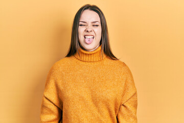 Young hispanic girl wearing casual clothes sticking tongue out happy with funny expression. emotion concept.