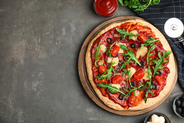 Pita pizza with cheese, olives, tomatoes and arugula on grey table, flat lay. Space for text