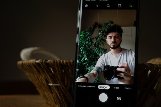 Young Caucasian Man On A Phone Screen, Pretending To Take A Picture